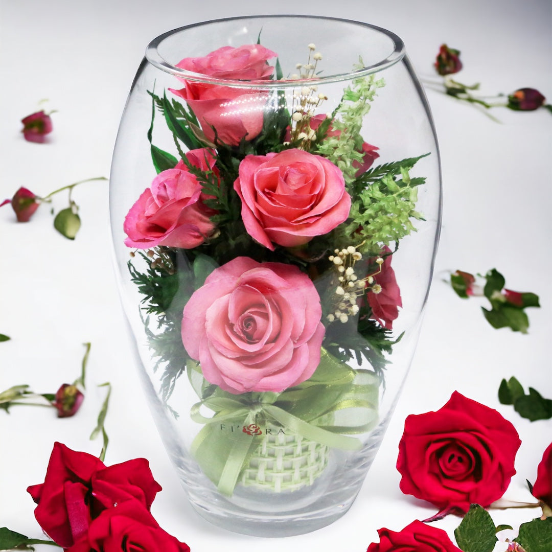 Rosy Charm: Seven Bright Pink Roses in an Elliptical Round Glass Vase